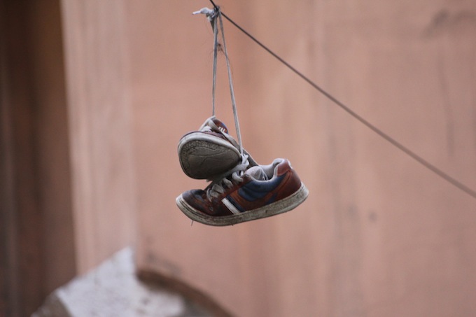 What is the reason for throwing shoes over a power line?