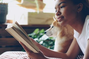 girl reading book beside dog; Photo by Vitaly Gariev on Unsplash